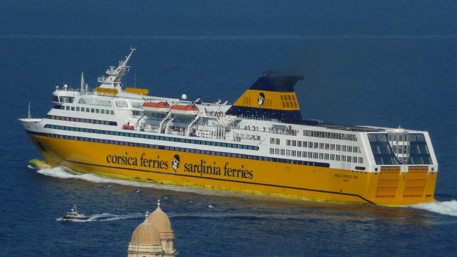 Le d&eacute;part du Mega Express Two de la Corsica Ferries, vu des hauteurs de la ville, en juillet 2013 (au premier plan, le sommet de l'&eacute;glise St Jean) ; photo : Romain Roussel
